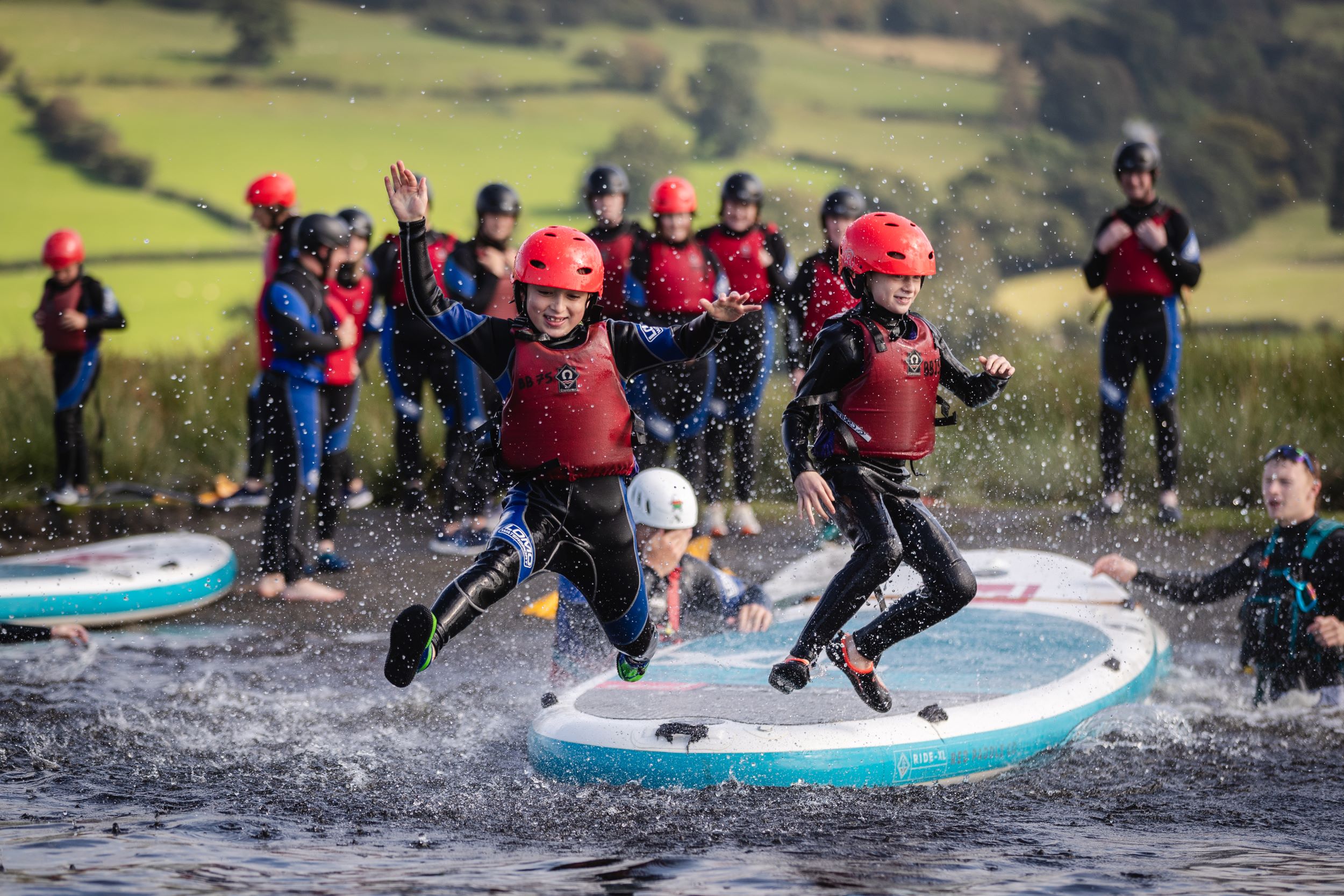 Plant yn neidio oddi ar SUP i'r llyn yng Nglan-llyn